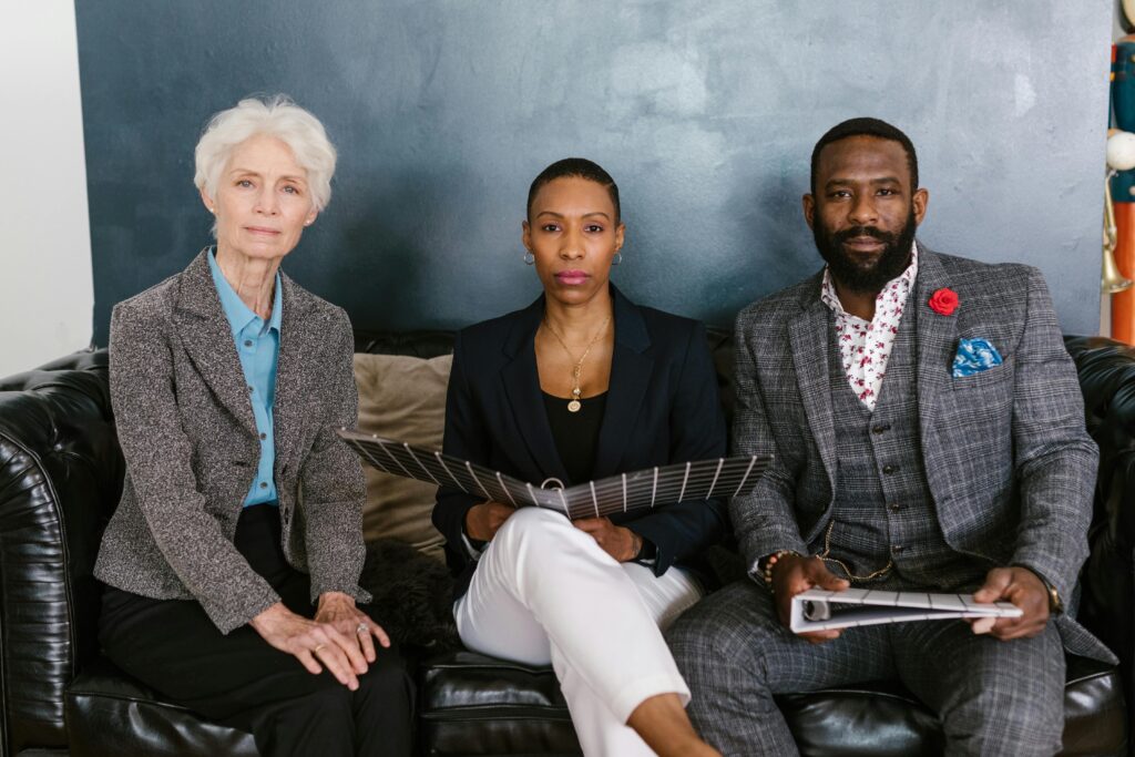 A diverse group of professionals sitting on a sofa in an office setting, showcasing teamwork and collaboration.